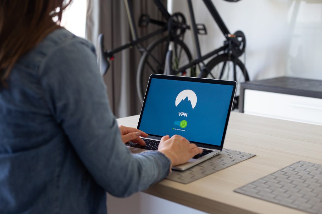 A person sitting at a table using a laptop computer