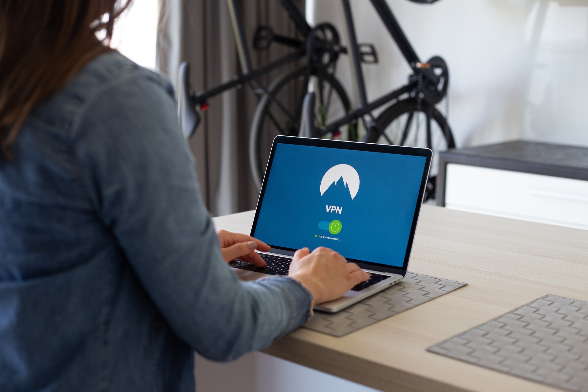 A person sitting at a table using a laptop computer
